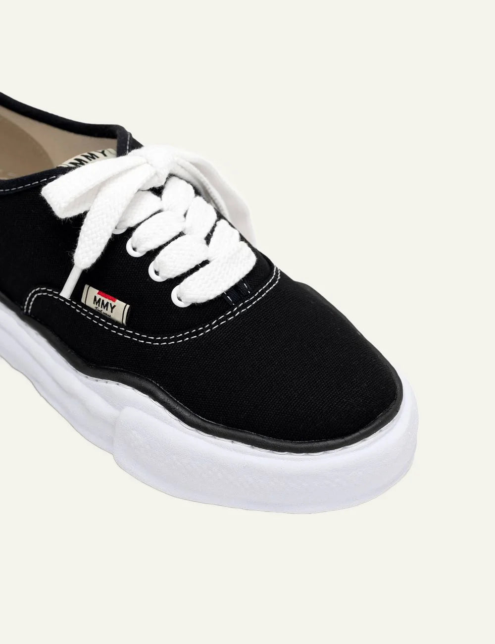 Maison Mihara Yasuhiro Baker low-top sneaker black, close-up στο canvas upper και white laces