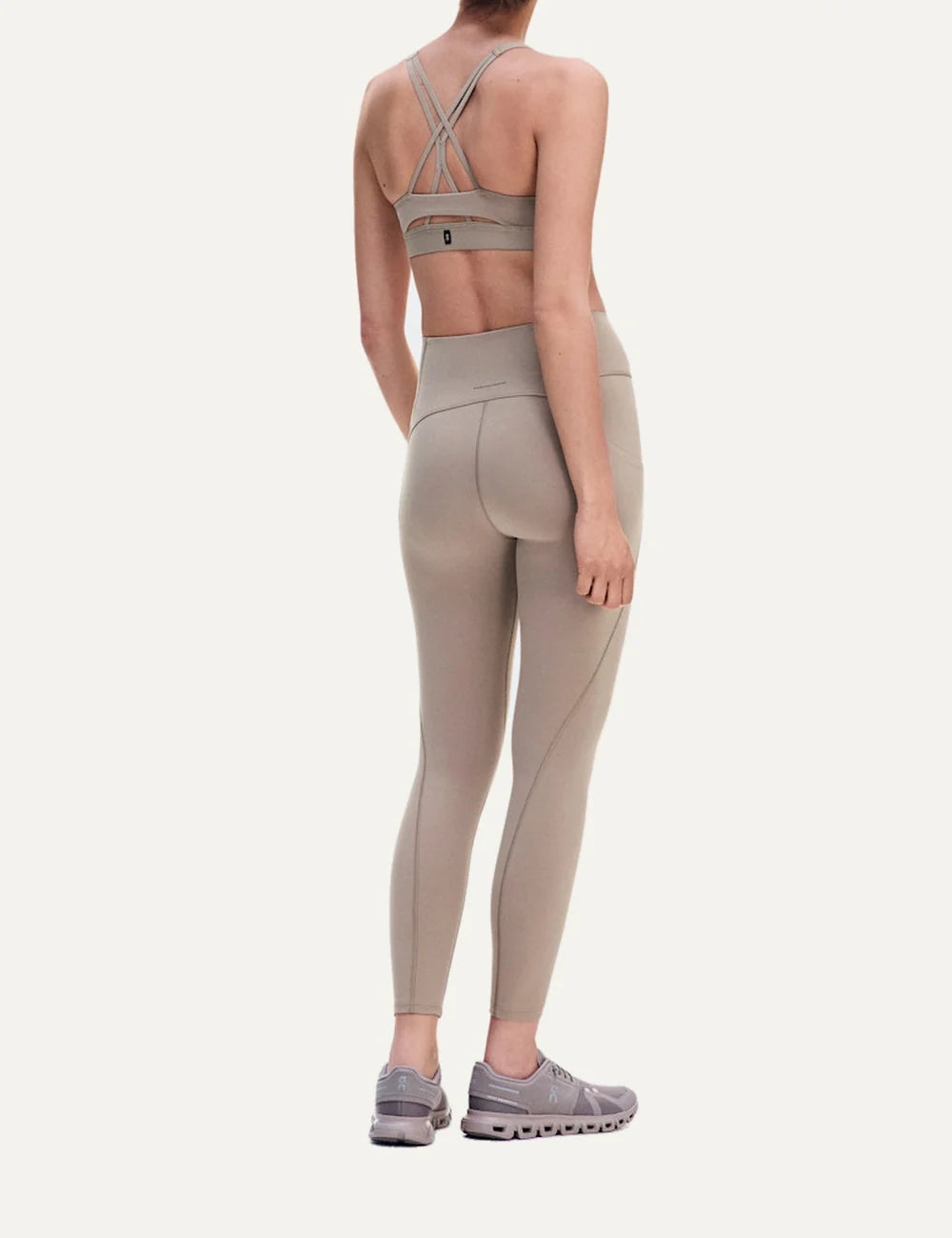 On women's beige sports bra with low support, scoop neckline, strappy open back, soft SenseTec stretch fabric, gentle elastic underband and moisture-wicking mesh lining back