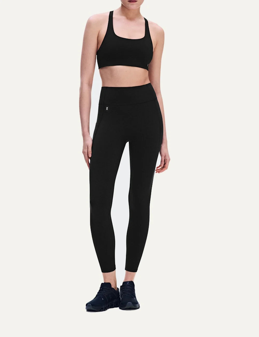 On women's black high-waisted athletic leggings with close fit, ankle length, soft SenseTec fabric, four-way stretch, seamless front and side phone pocket.