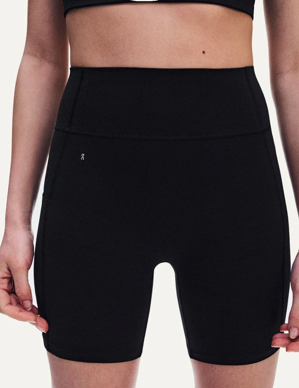 On women's black high-waisted biker shorts with close fit, soft SenseTec fabric, four-way stretch, seamless front, wide supportive waistband and side phone pocket.
