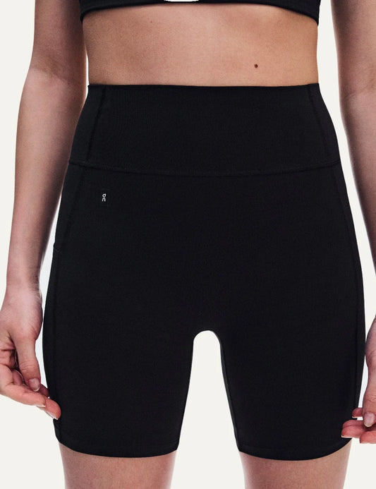 On women's black high-waisted biker shorts with close fit, soft SenseTec fabric, four-way stretch, seamless front, wide supportive waistband and side phone pocket.
