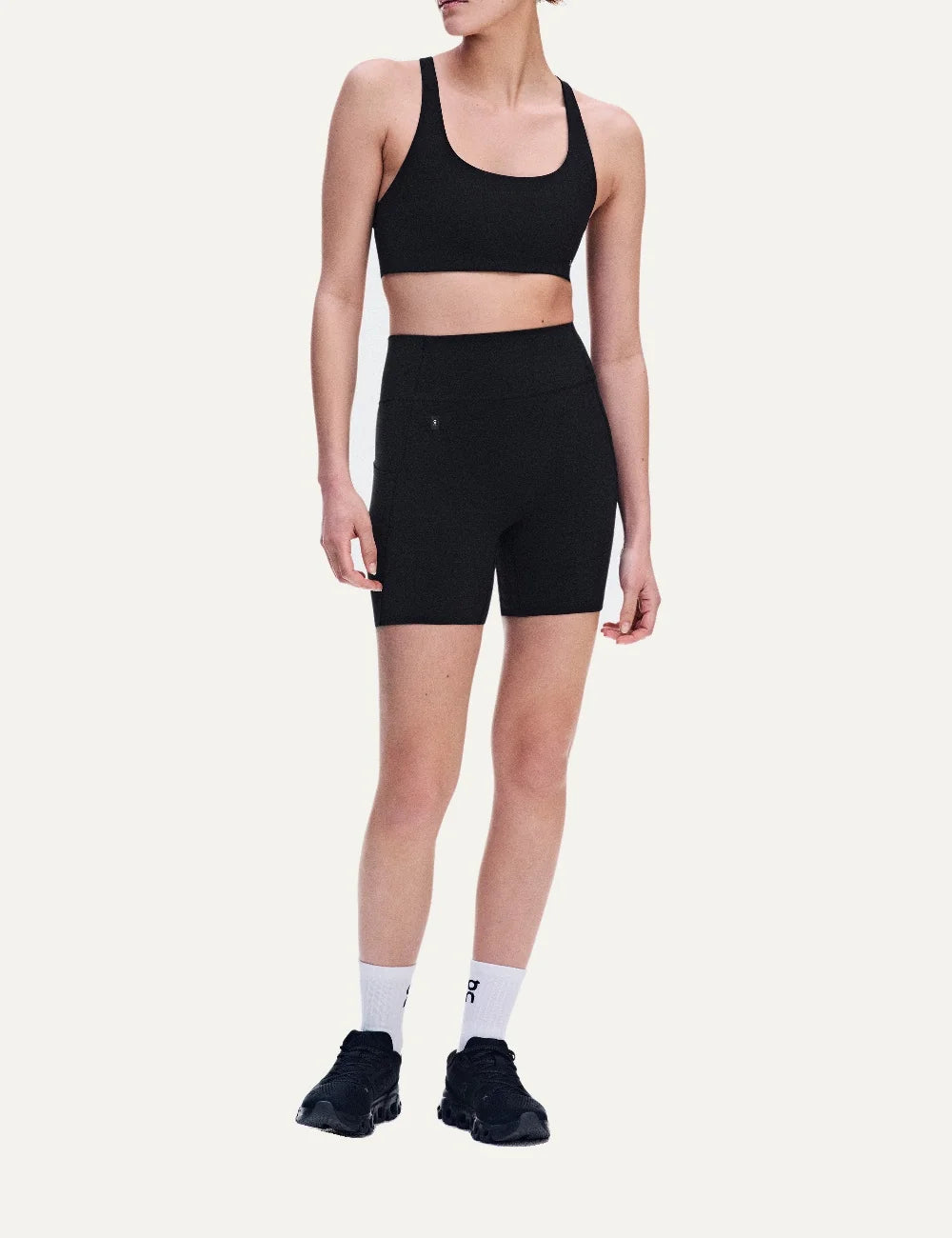 On women's black high-waisted biker shorts with close fit, soft SenseTec fabric, four-way stretch, seamless front, wide supportive waistband and side phone pocket full body