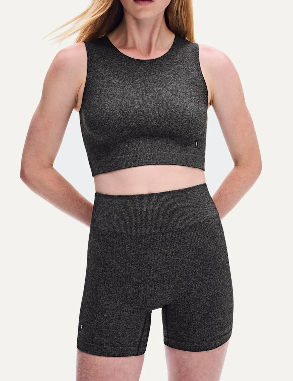 On women's dark grey heathered high-waisted biker shorts with close fit, soft textured knit, seamless feel, four-way stretch fabric and On logo.