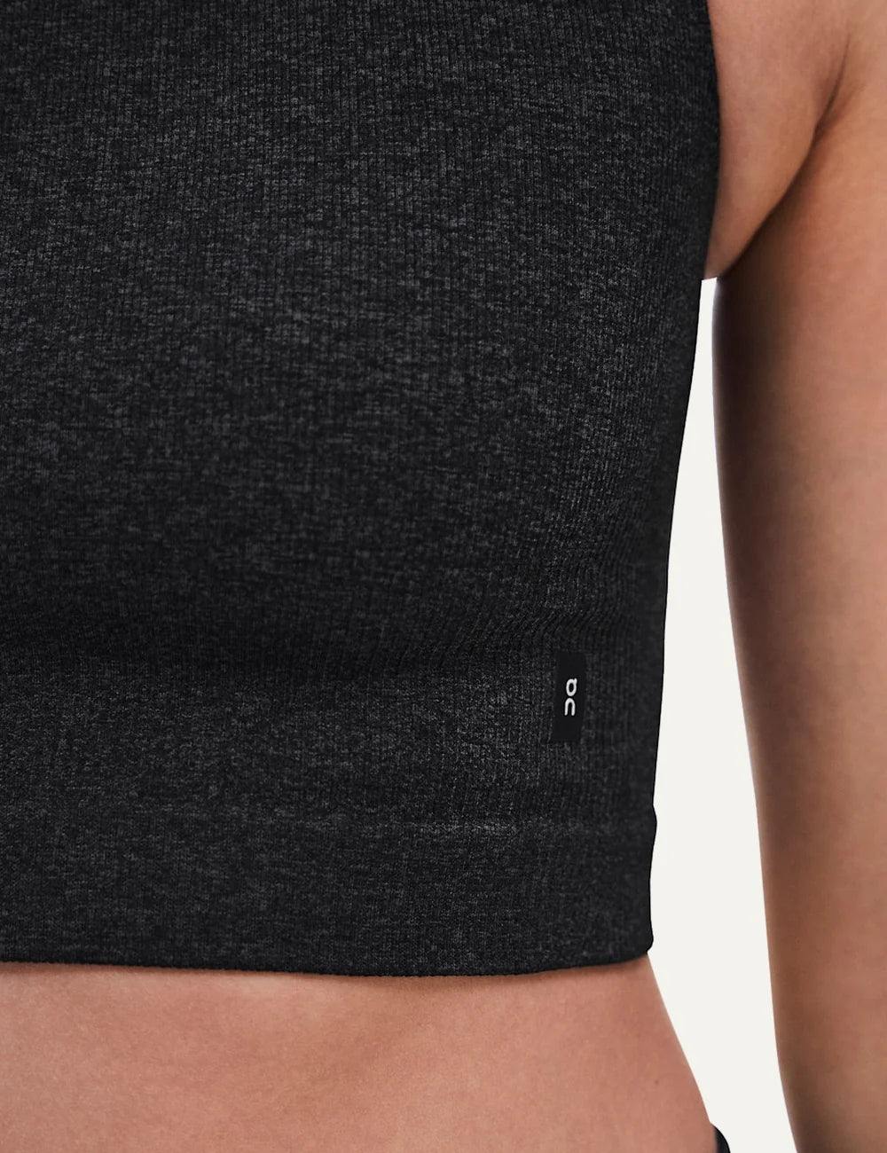 On women's dark grey heathered crop athletic top with sleeveless design, round neckline, soft textured knit, four-way stretch fabric and bonded edges detail