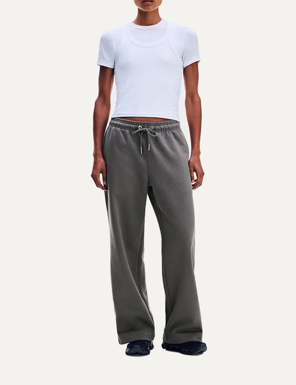 On women's grey relaxed fit sweatpants with wide straight legs, elastic drawstring waistband, soft brushed lining, side pockets and embroidered logos.
