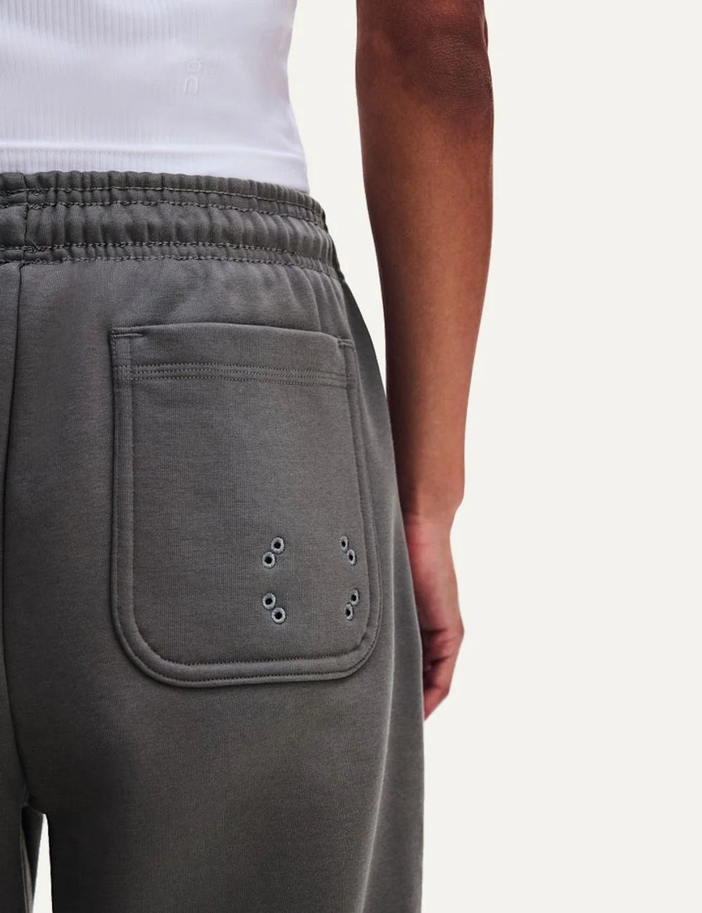 On women's grey relaxed fit sweatpants with wide straight legs, elastic drawstring waistband, soft brushed lining, side pockets and embroidered logos detail