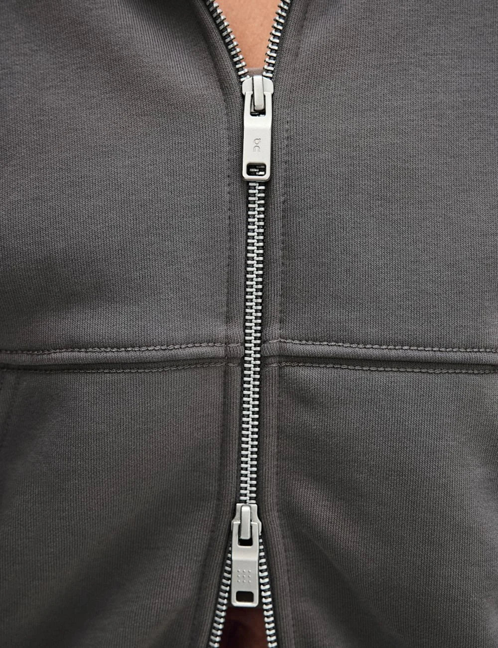 On women's grey zip-up hoodie with relaxed fit, drawstring hood, front pockets and embroidered logo detail