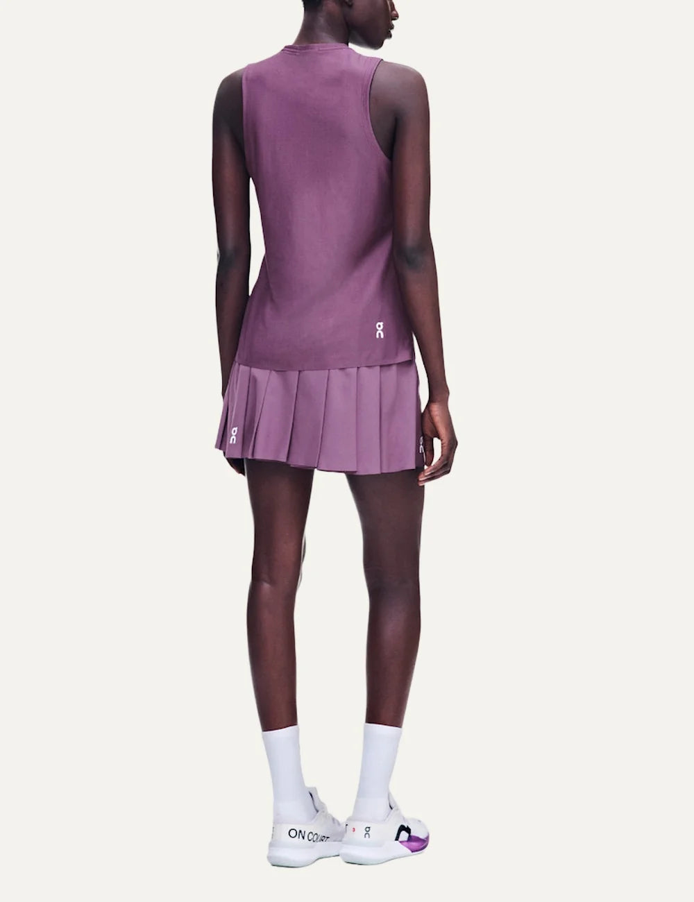 On women's purple pleated tennis skirt with integrated inner shorts back