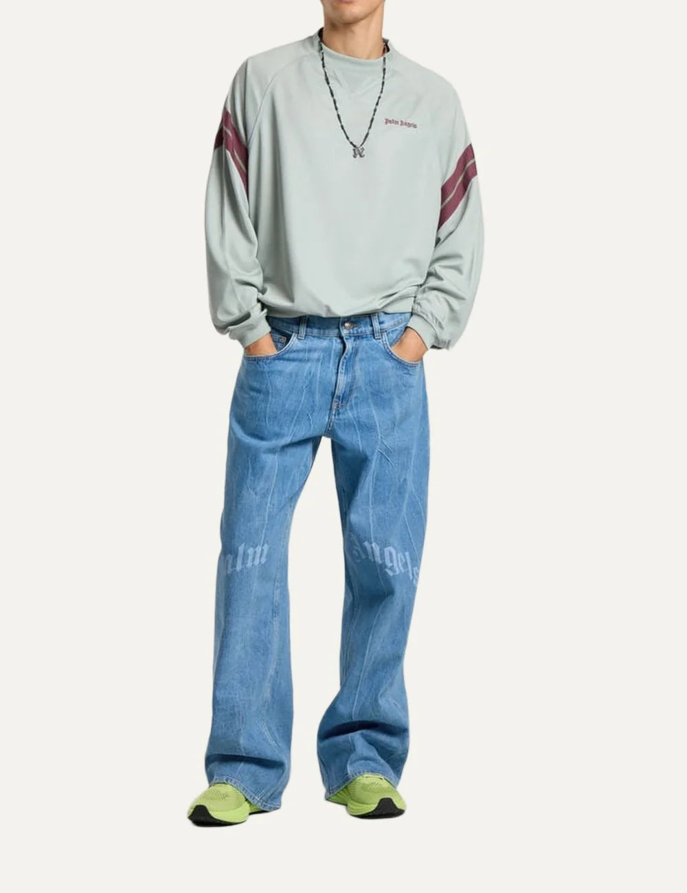 Palm Angels men's light blue washed loose fit jeans with wide straight legs, five-pocket design and split gothic Palm Angels logo across the front thighs full body