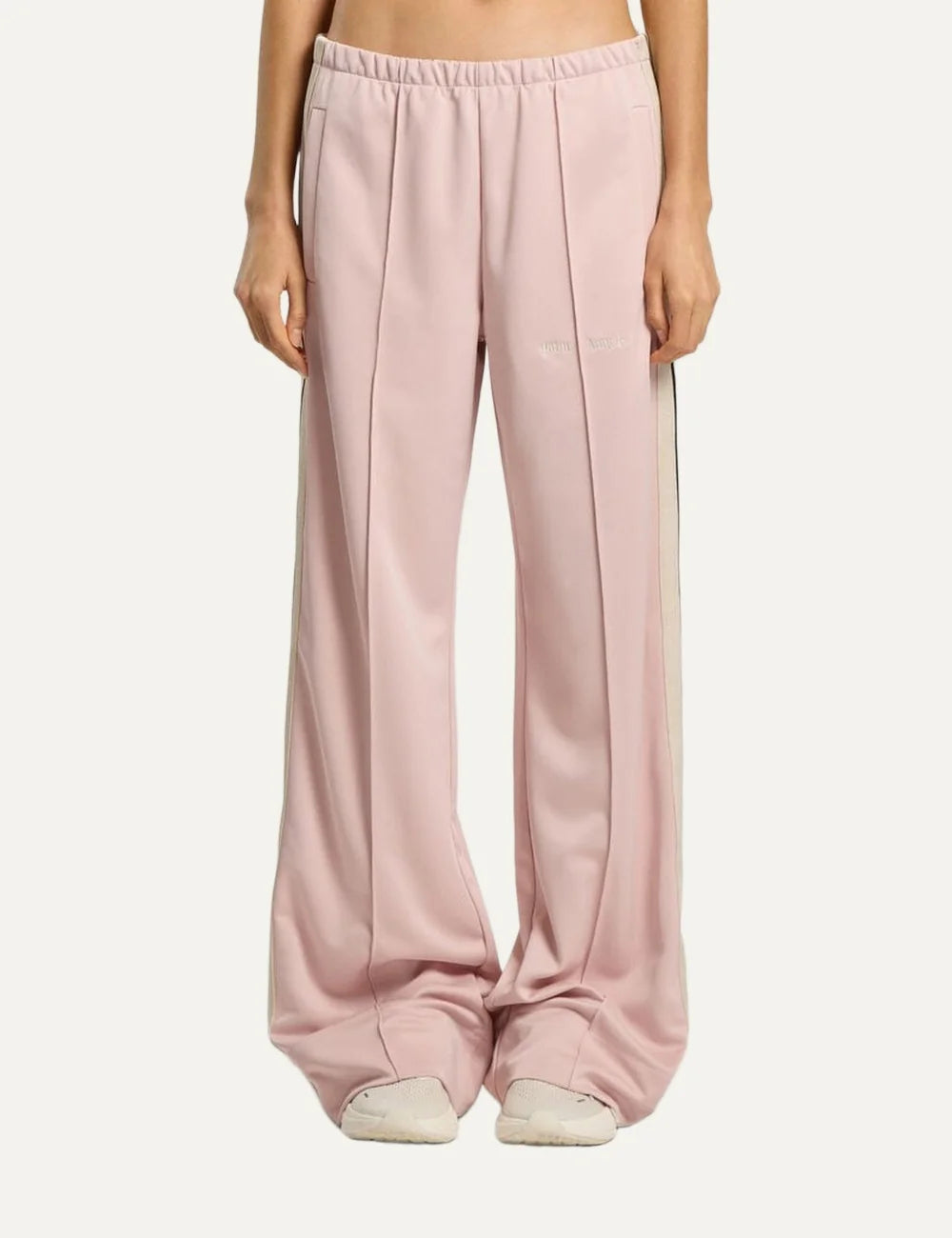 Palm Angels women's light pink wide leg track pants with black and white side stripes, elastic waistband, front pintuck pleats and embroidered logo model