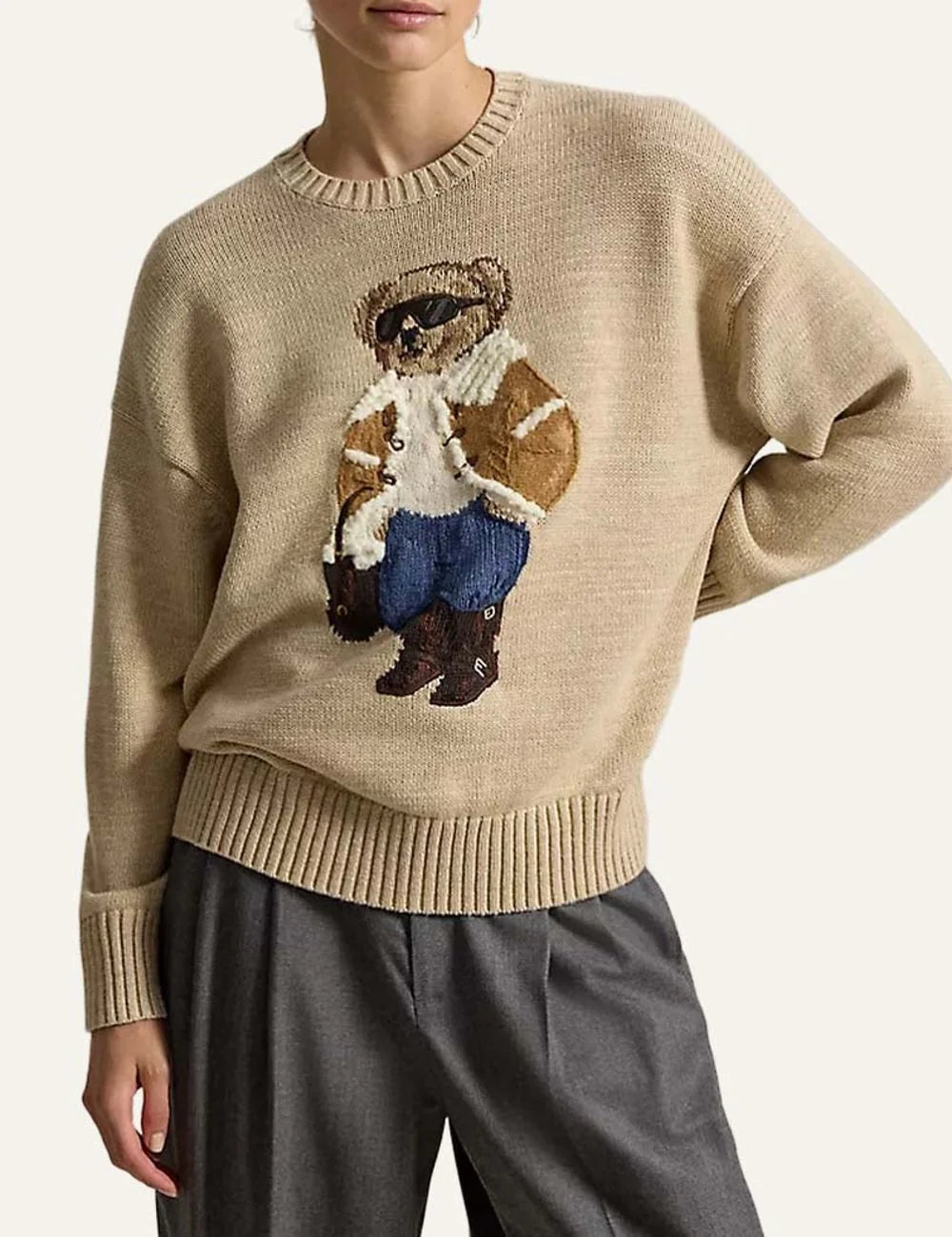Polo Ralph Lauren men's beige cotton knit sweater featuring a Polo Bear in a shearling jacket, sunglasses and blue jeans, with ribbed trims model