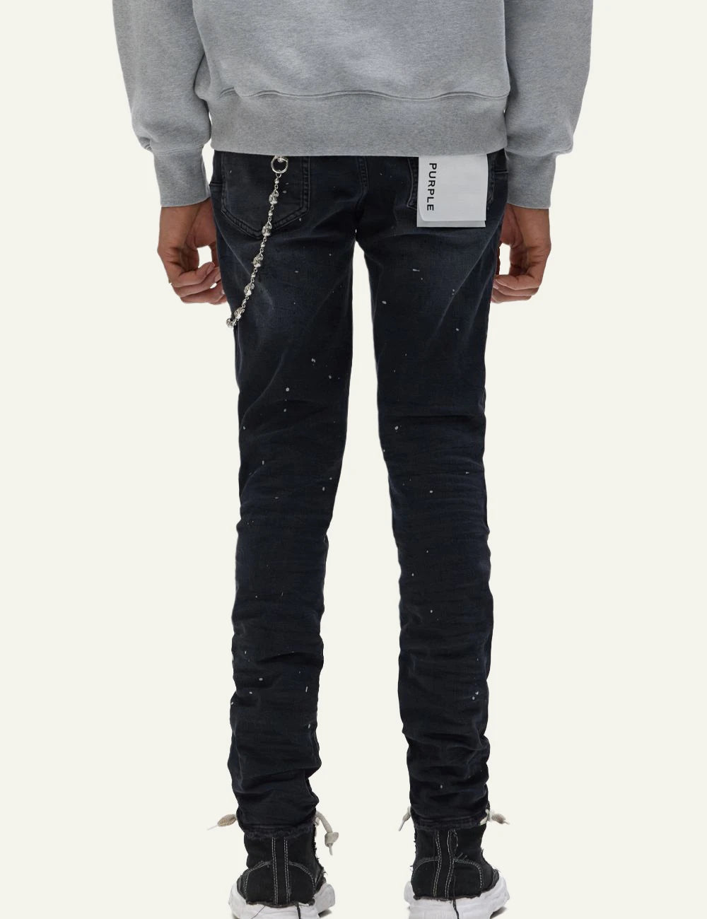 Purple Brand black skinny jeans with distressed knees and paint splatter back view