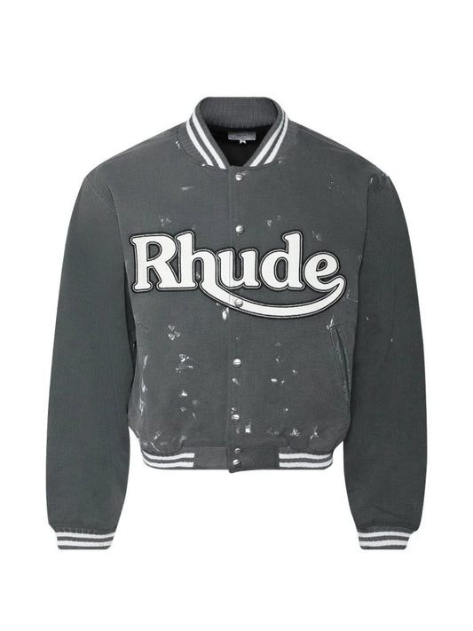Rhude men's grey washed cotton varsity jacket with oversized white logo patch, paint-splatter details, snap buttons and striped ribbed trims.