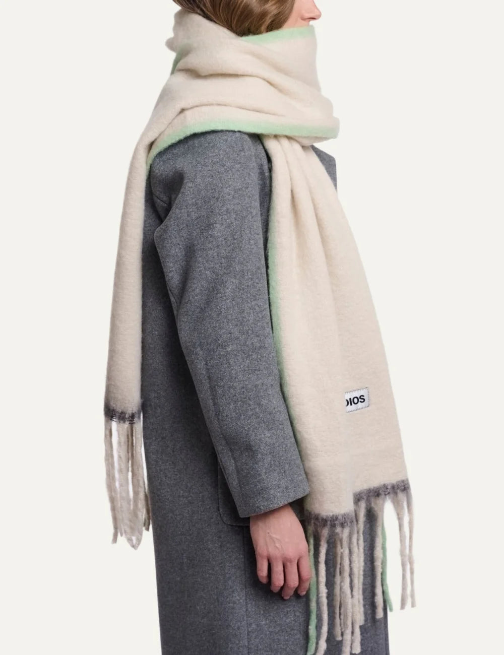 Rino Pelle women's oversized cream scarf with soft lime green accents, long fringes and Rino Studios logo patch side