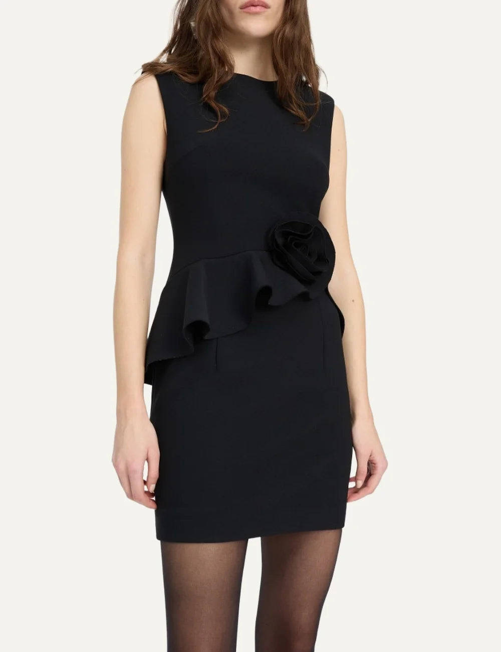 Rotate women black mini dress with structured shoulders, waist ruffle and large rose detail at the hip model