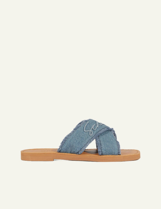 Schutz denim flat sandal with frayed X straps and logo detail side view