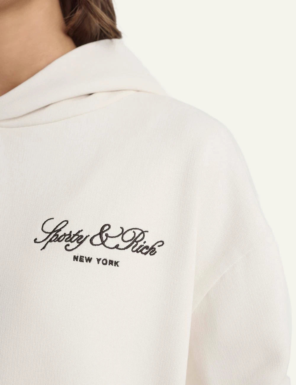 Sporty and Rich ecru hoodie embroidered logo front detail view