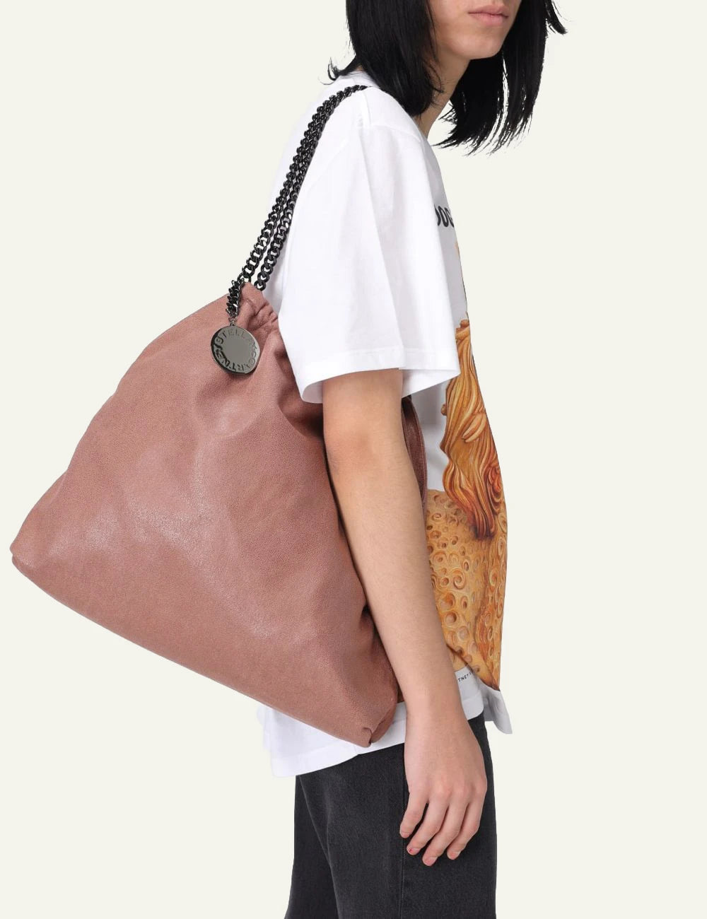 Stella McCartney Falabella clutch bag in dusty pink vegan leather with chain shoulder strap and logo charm, front model view