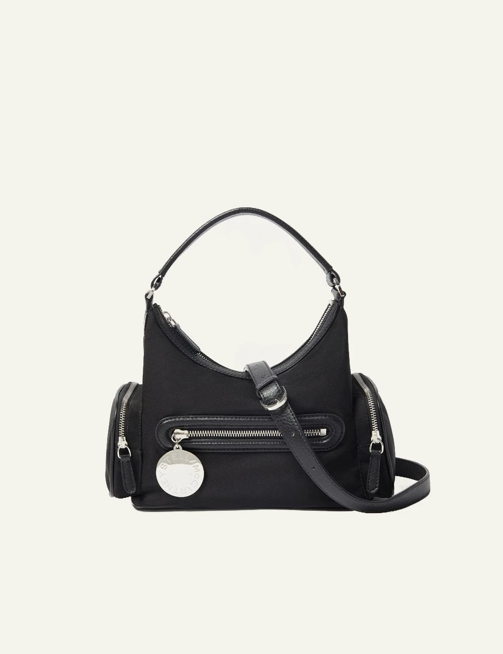 Stella McCartney shoulder bag in black vegan leather with front zip pocket, side compartments and logo coin charm, front view