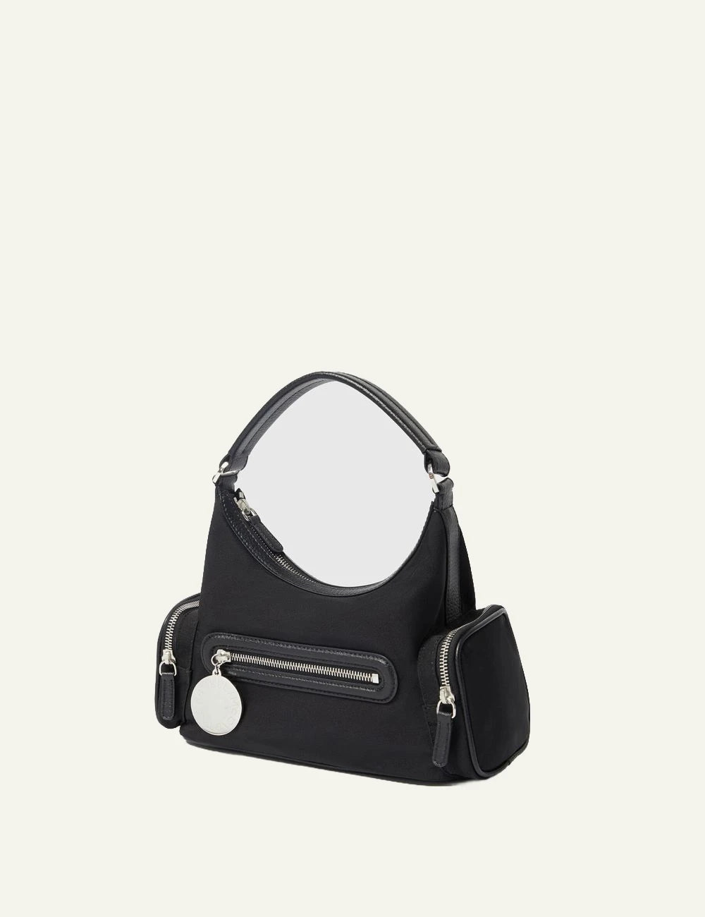 Stella McCartney shoulder bag in black vegan leather with front zip pocket, side compartments and logo coin charm, side view