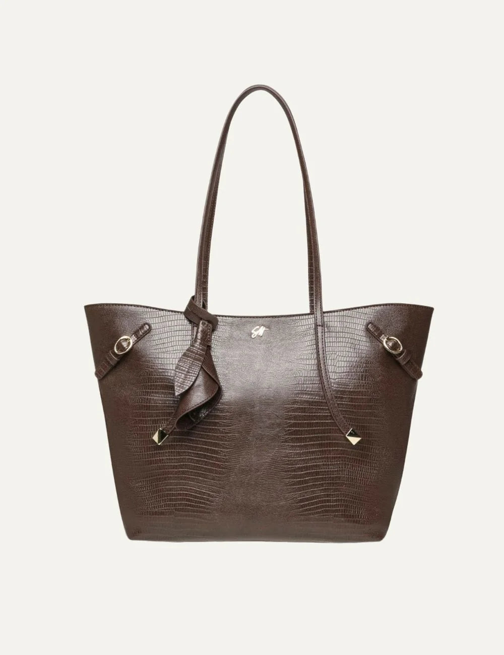 Steve Madden Bdelphin women's chocolate brown tote shoulder bag with embossed lizard effect texture, two long handles, decorative buckle straps, gold tone hardware and small front logo, front view.