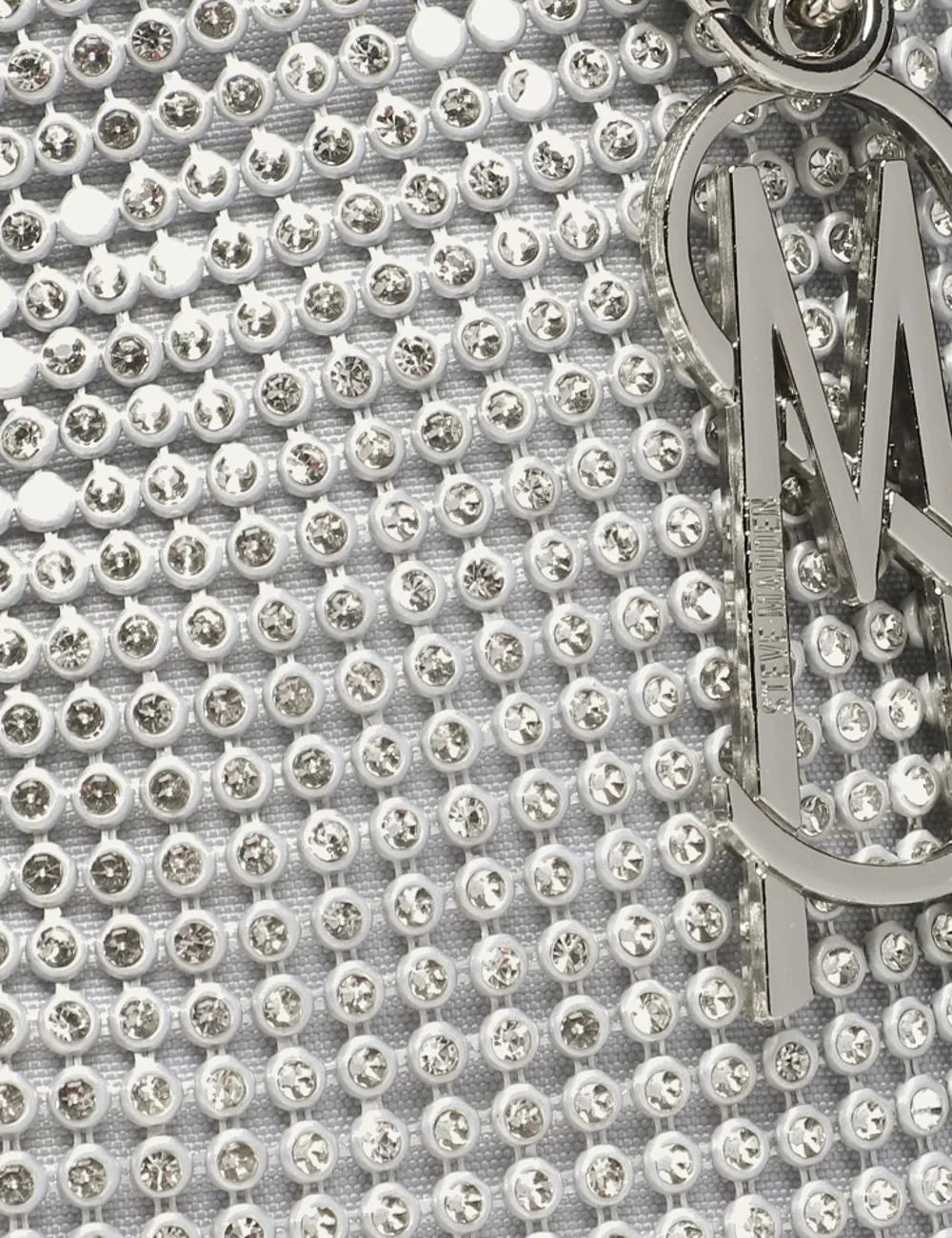 Steve Madden Bkaya women's silver rhinestone embellished shoulder bag with curved silhouette, detachable knotted rhinestone strap, silver tone hardware, side chain charm and top zipper, close up details