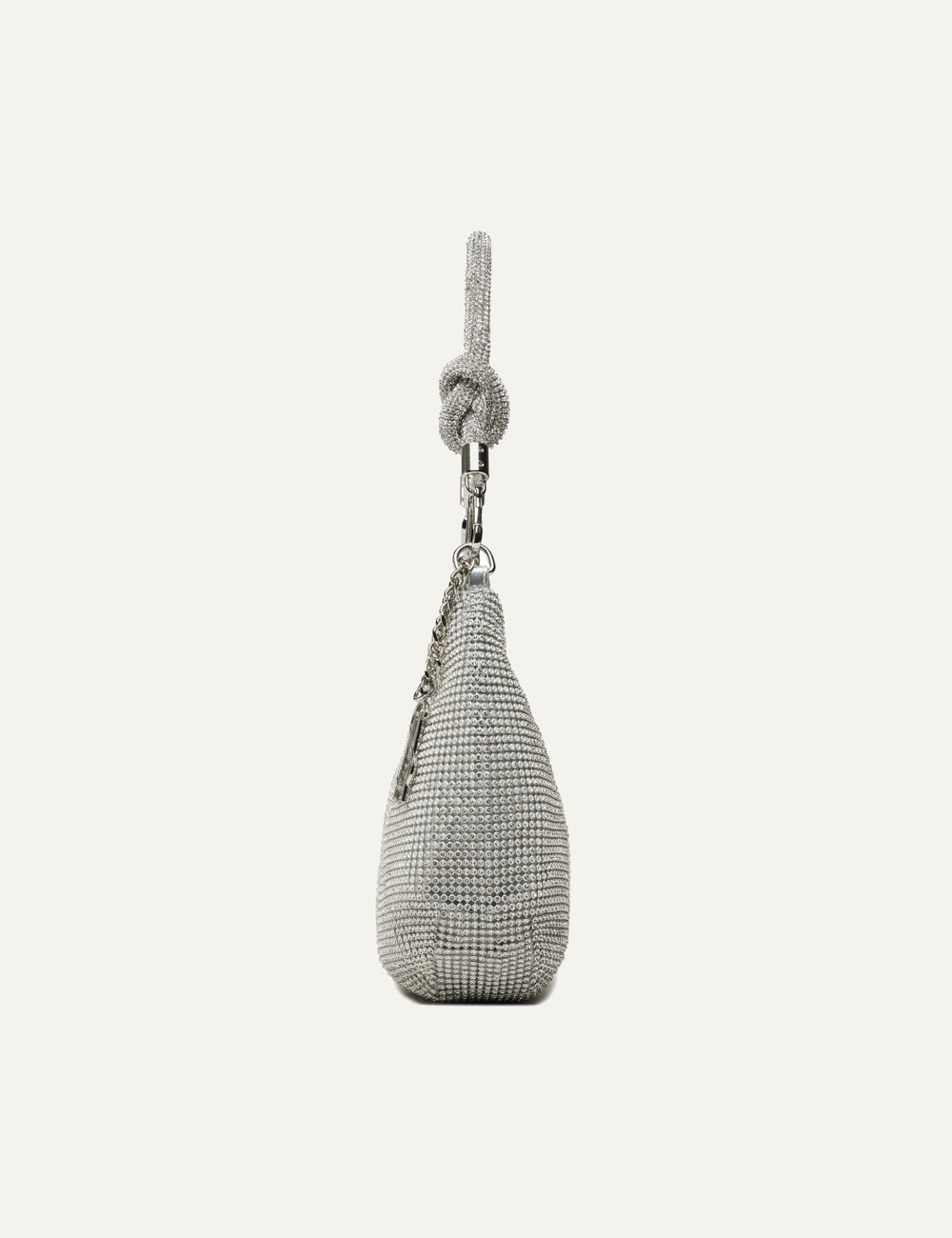 Steve Madden Bkaya women's silver rhinestone embellished shoulder bag with curved silhouette, detachable knotted rhinestone strap, silver tone hardware, side chain charm and top zipper, side view