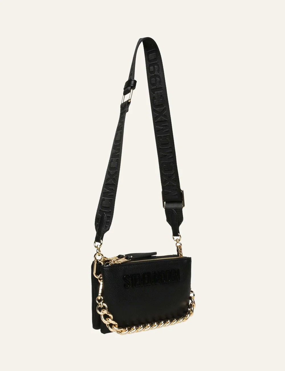 Steve Madden women's black synthetic crossbody bag with embossed logo, adjustable branded shoulder strap, gold tone chain detail along the bottom and top zip closure, side view