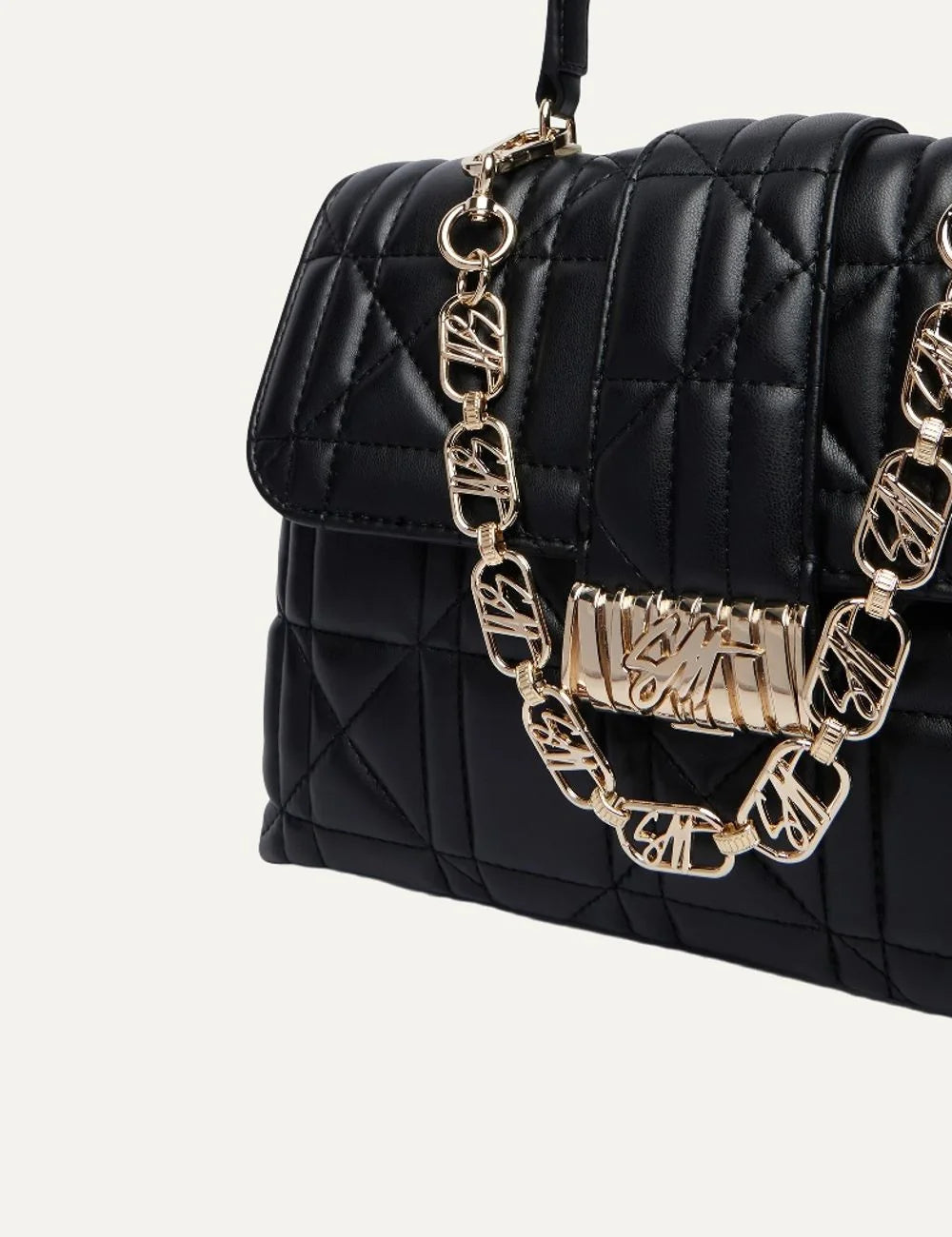 Steve Madden Bvault women's black quilted faux leather structured handbag with gold tone logo chain, top handle, front flap clasp and adjustable shoulder strap,  close up view