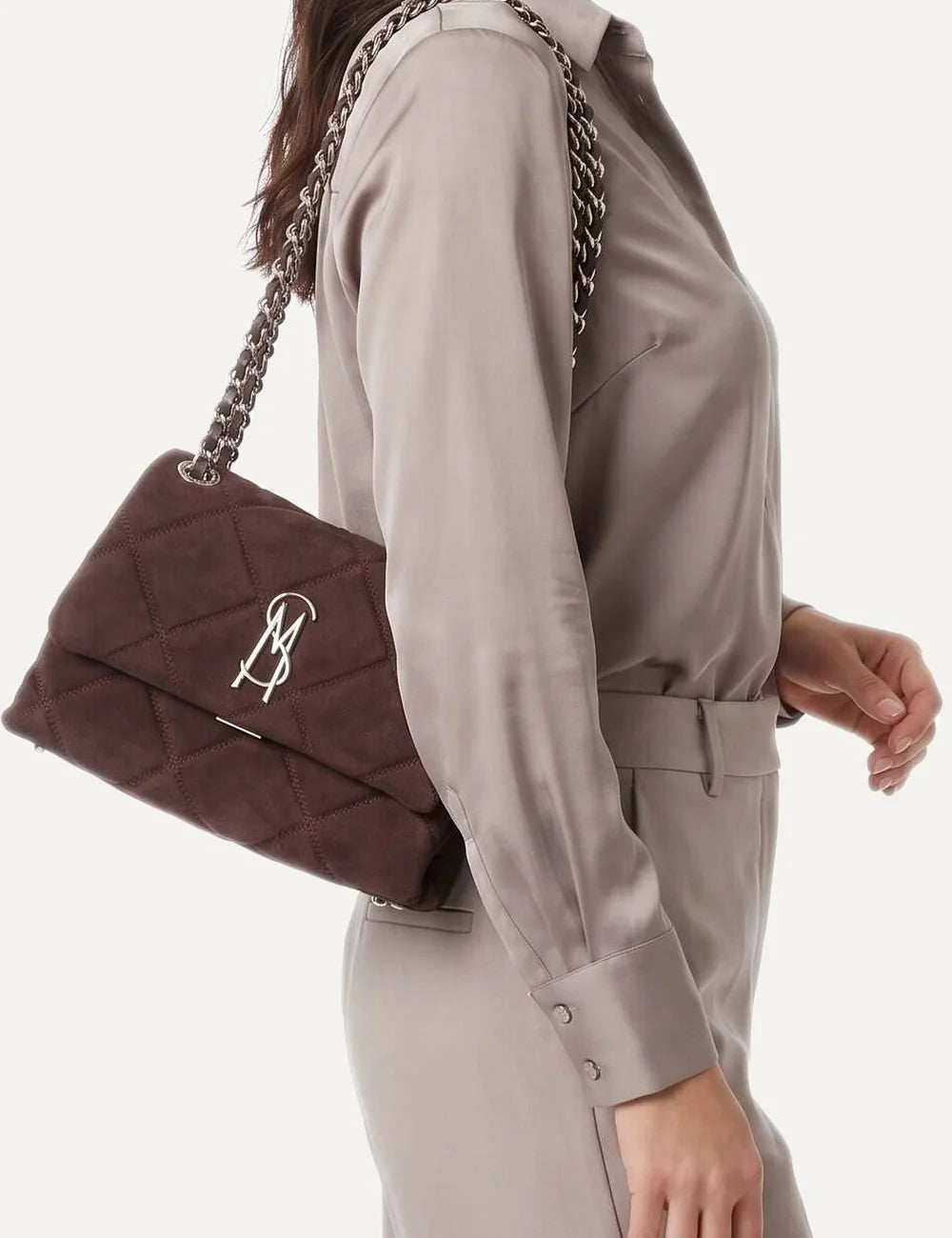 Steve Madden BVOLT-S women's dark brown quilted suede effect shoulder bag with diamond stitching, silver tone metal logo, flap closure and interwoven chain shoulder strap, on model
