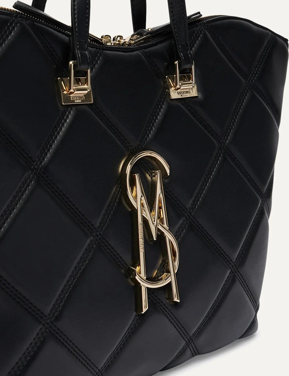 Steve Madden BVUSE women's black quilted faux leather tote bag with large diamond stitching, gold tone metal logo, two long shoulder handles and top zipper closure,  close up view