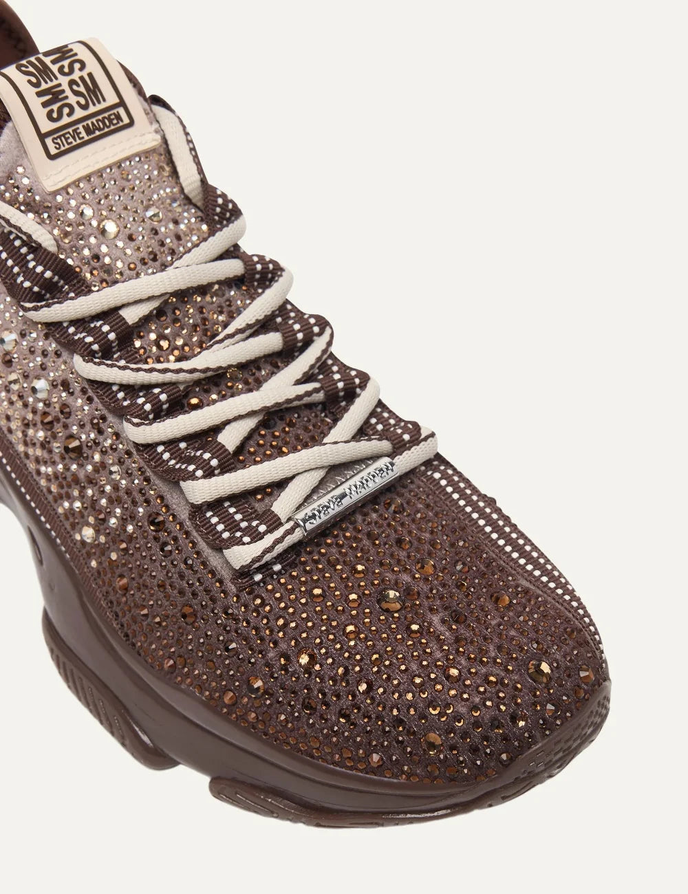 Steve Madden Mistica women's chunky sneakers in brown and taupe, embellished with sparkling rhinestones, featuring a gradient textile upper, beige and brown laces, oversized Steve Madden side logo and glossy brown sculpted sole, close up details