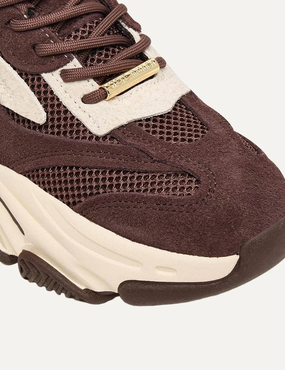 Steve Madden Possession-E women's chunky sneakers in brown and off-white, featuring suede-effect overlays, brown mesh panels, off-white side accents, lace-up fastening, Steve Madden side logo and oversized cream sculpted sole,  close up view