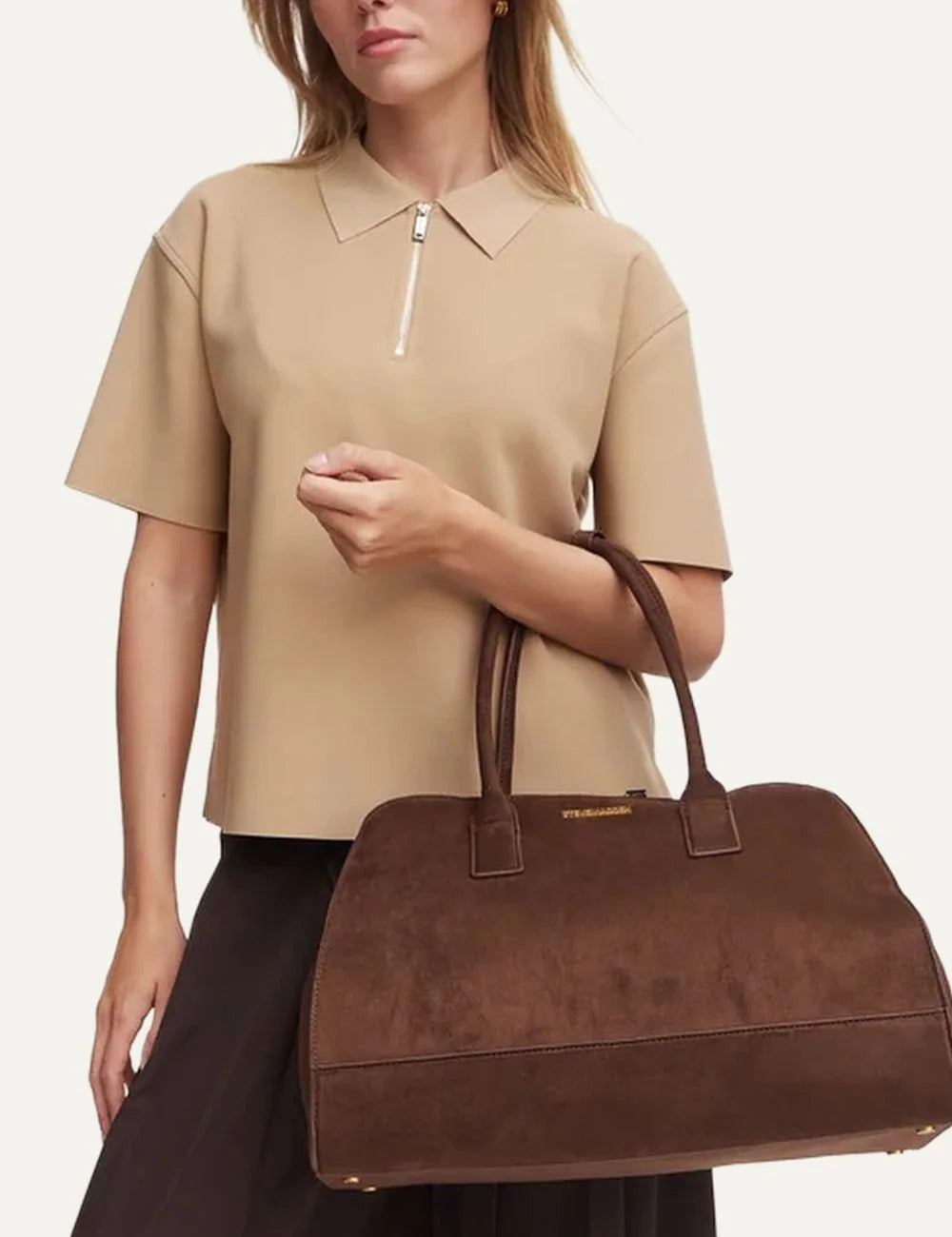Steve Madden women's chocolate brown suede leather structured shoulder bag with two long handles, curved top, gold tone front logo, zip closure and reinforced base,  on model