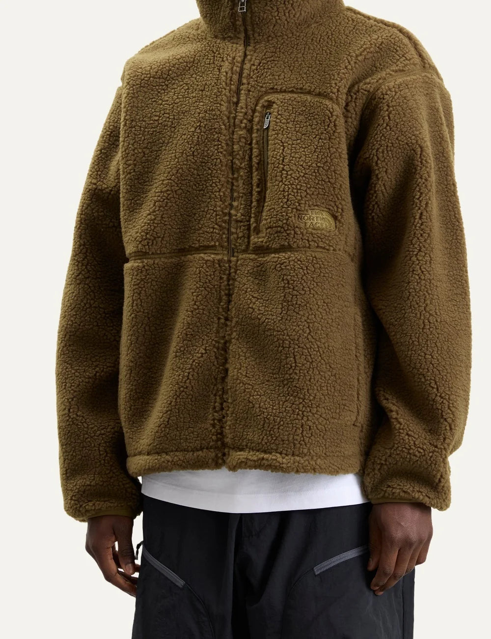 The North Face men's olive green Extreme Pile fleece jacket with textured sherpa fabric, high collar, front zipper and chest pocket model