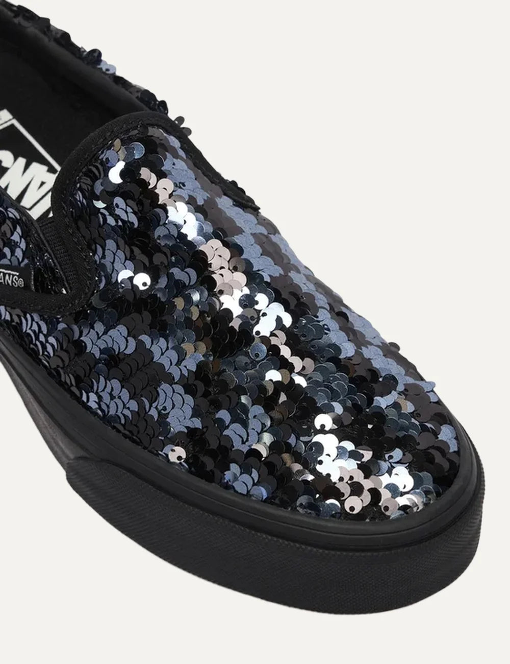 Vans Classic Slip-On women's black sneakers with black and silver sequins, elastic side panels and black rubber sole close up detail