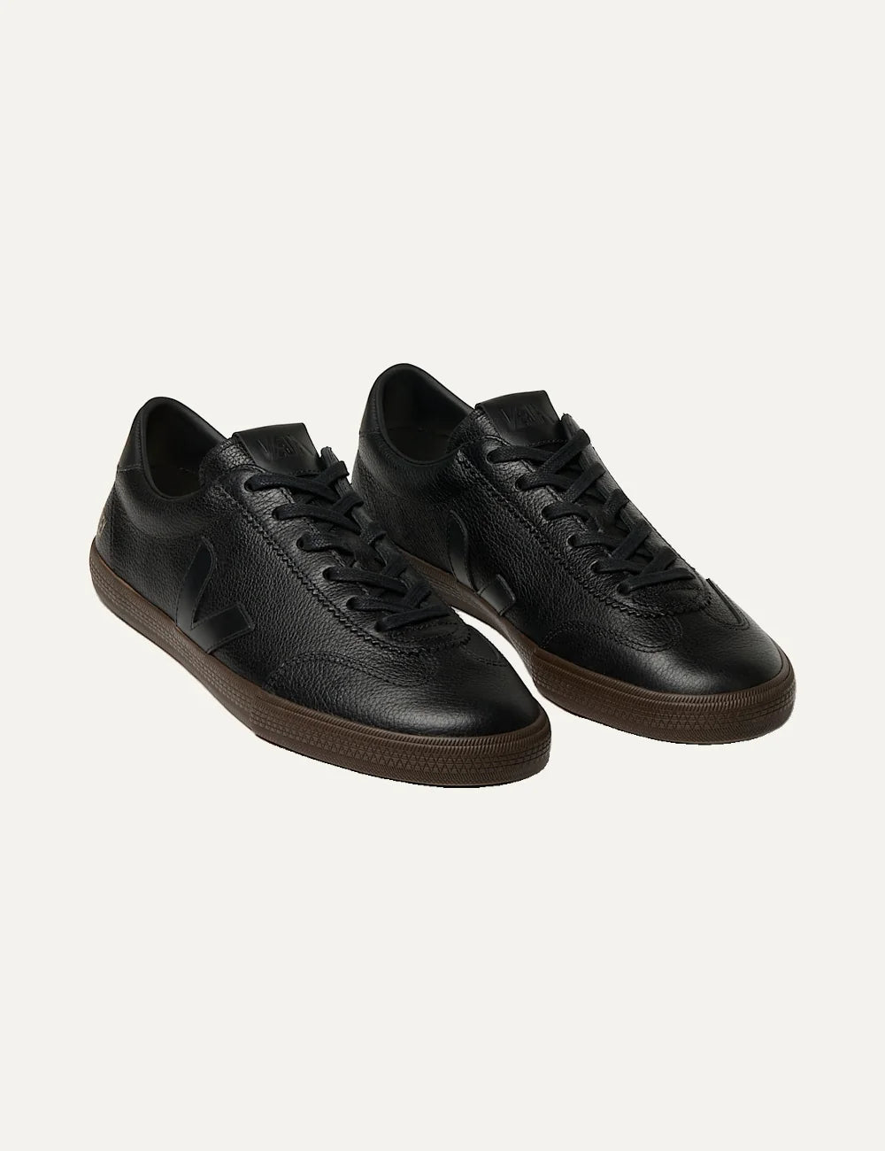 VEJA women's Volley Signature black leather sneakers with tonal V logo, gold branding, black laces and dark brown rubber sole angled