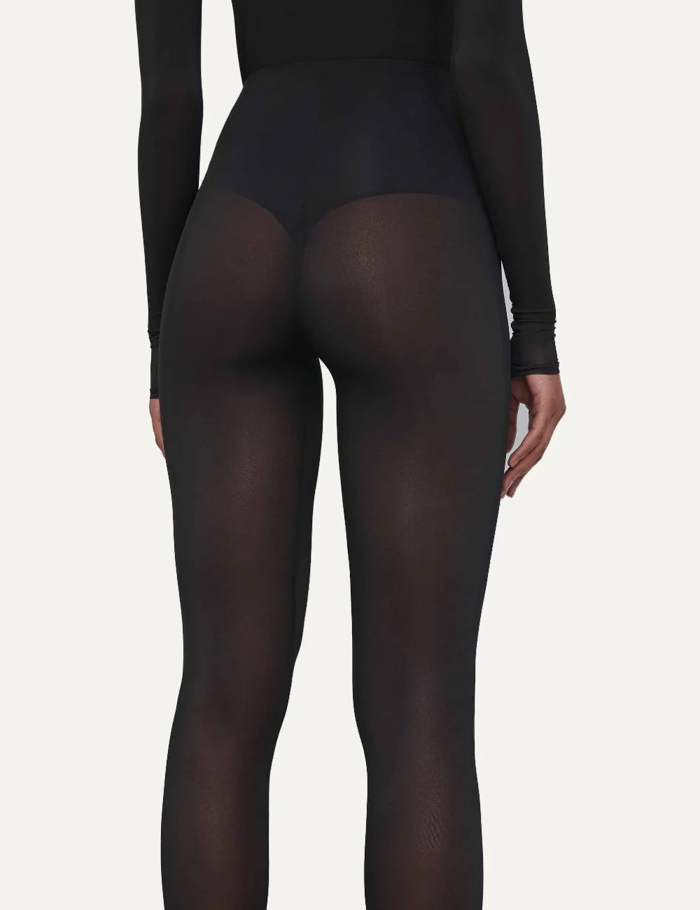 Wardrobe NYC women's black sheer tights in Italian stretch fabric featuring a translucent finish, high elasticated waist, form-fitting silhouette and full-length legs back