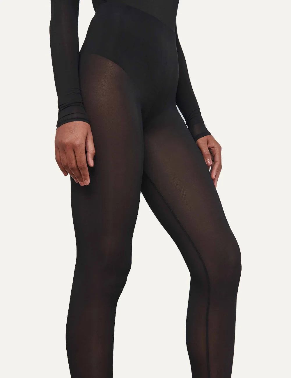 Wardrobe NYC women's black sheer tights in Italian stretch fabric featuring a translucent finish, high elasticated waist, form-fitting silhouette and full-length legs side