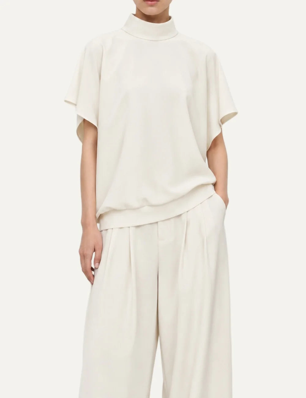 Women's Eleh ecru high-neck blouse with loose short sleeves, flowing draped silhouette and deep V-back opening model